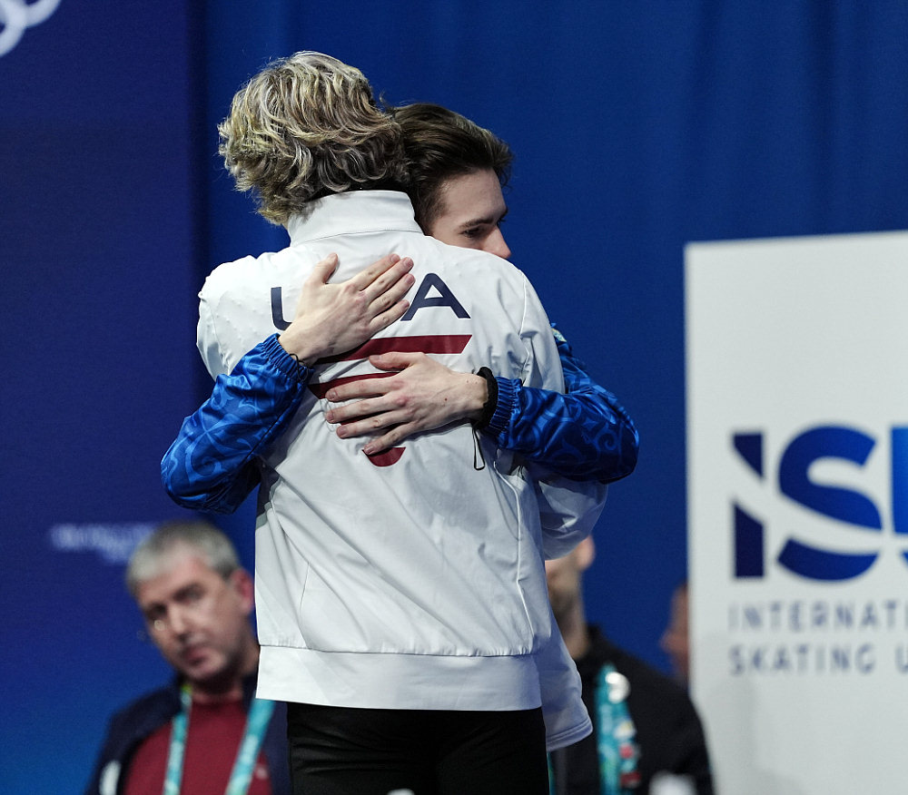 Илья Малинин (спиной) поздравляет Михаила Шайдорова с победой на Олимпиаде в Милане